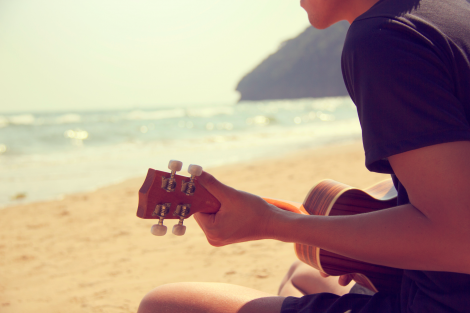 Man-playing-guitar-on-the-beach